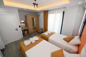 two beds in a hotel room with towels on them at Villa Bağ Tepesi in Fethiye +48 photos