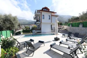 a villa with a swimming pool and patio furniture at Villa Bağ Tepesi in Fethiye