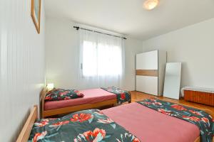 a room with three beds and a window at Apartment Davor 2330 in Pula