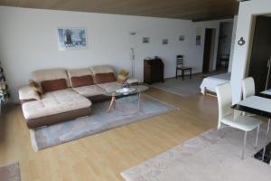 ein Wohnzimmer mit einem Sofa und einem Tisch in der Unterkunft Appartement Alpenblick A1 in Weggis