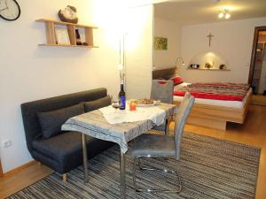 a living room with a table and a bed at Ferienwohnung in Bad Bayersoien mit Terrasse, Grill und Garten in Bad Bayersoien