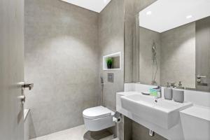 a bathroom with a white sink and a toilet at Premium 1-BR with Exquisite Layout in District One in Dubai +15 photos
