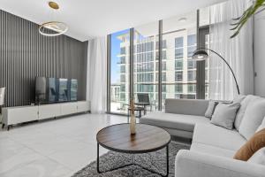 a living room with a couch and a tv at Premium 1-BR with Exquisite Layout in District One in Dubai