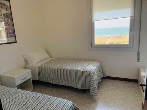 1 dormitorio con 2 camas y ventana en Hotel Mayer en Bibione