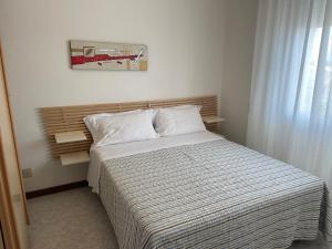 a bedroom with a bed with a striped comforter at Hotel Mayer in Bibione