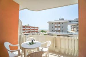 a balcony with a table and chairs and a view of a city at Hotel Mayer in Bibione