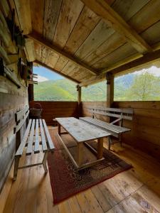 a table and benches in a cabin with a view at Household Babovic - Old house Miljan's valley in Andrijevica