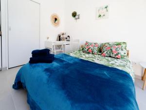 a bedroom with a bed with a blue blanket at Gite Le Cocon de Lily in Saint-Savin-de-Blay +30 photos