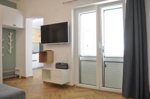 ein Wohnzimmer mit einem TV und einer Glasschiebetür in der Unterkunft STARA GAVZA - bungalows , apartments in Cres