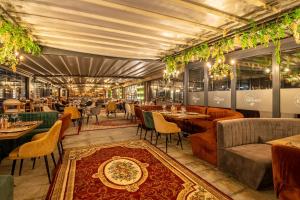 een restaurant met tafels en stoelen en een tapijt bij Paradiso Dreams Hotel in Nesebar