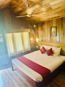 a large bed in a room with wooden walls at PRISTINE BEACH RESORT in Diglipur