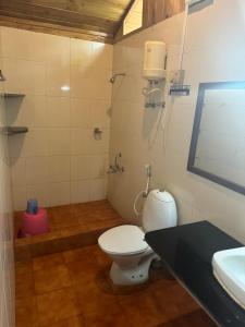 a bathroom with a toilet and a sink at PRISTINE BEACH RESORT in Diglipur +10 photos