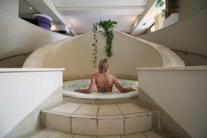 a man sitting in a bath tub in a spiral staircase at Corinthia St George's Bay in St. Julianʼs