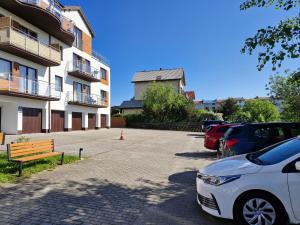 a parking lot with cars parked next to a building at Apartament Levante in Władysławowo
