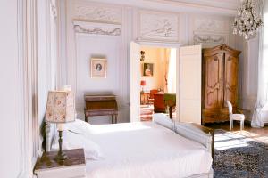 Habitación blanca con cama y escritorio en Le château de Bonnemare - Bed and breakfast, en Radepont