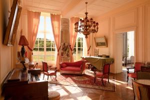 ein Wohnzimmer mit einem roten Sofa und einem Tisch in der Unterkunft Le château de Bonnemare - Bed and breakfast in Radepont