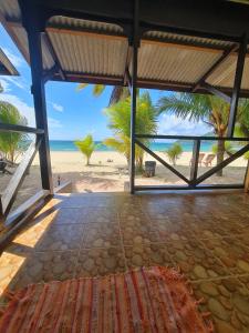 an open room with a view of the beach at Rainbow Tioman Cottage in Kampong Juara