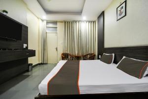 Habitación de hotel con cama grande y TV en Collection O Hotel Silver Inn, en Bhopal