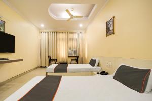 Habitación de hotel con 2 camas y TV de pantalla plana. en Collection O Hotel Silver Inn, en Bhopal