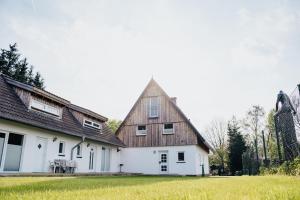 una grande casa bianca con tetto in legno di Ferienwohnung Gitte a Schneverdingen