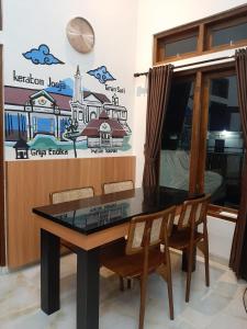 uma sala de jantar com mesa e cadeiras em Griya Endika Syariah em Yogyakarta