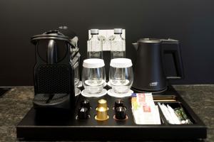 a tray with a coffee maker and glasses on a counter at OLD TOWN SNAIL Design Apartments in Bucharest +40 photos