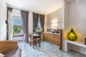 ein Wohnzimmer mit einem Tisch und eine Küche mit einem Fenster in der Unterkunft Country Agritur Tenuta Corte Tese 2 in Sona