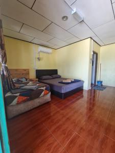 een kamer met een bed en een bank erin bij Rainbow Tioman Cottage in Kampong Juara