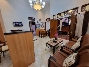 - un salon avec un canapé et une table dans l'établissement Griya Endika Syariah, à Yogyakarta