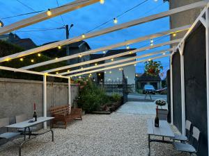 un patio avec deux tables, des bancs et des lumières dans l'établissement Belgica-Melay 52400, à Melay