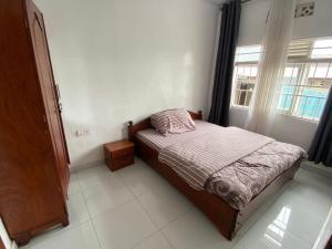um pequeno quarto com uma cama e uma janela em BIZI HOMES em Kigali