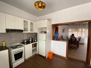 een keuken met witte apparatuur en een persoon aan een tafel bij BIZI HOMES in Kigali