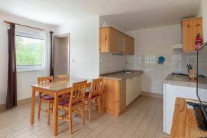 una cocina con mesa de madera y sillas. en Apartments Bor, en Bohinj