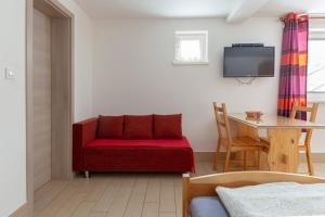 a living room with a red couch and a table at Apartments Bor in Bohinj