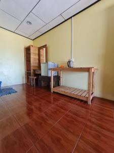 een kamer met een houten vloer en een tafel bij Rainbow Tioman Cottage in Kampong Juara