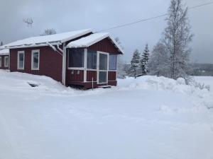 a small red house with snow on top of it at Rödvattnet cottages in Rödvattnet