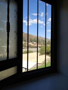 une fenêtre ouverte avec vue sur un champ dans l'établissement casa montañista lodge & camping, à Huaraz
