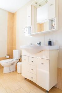 uma casa de banho branca com um WC e um lavatório em Koroni Family house with the best view 84 sqm em Koroni