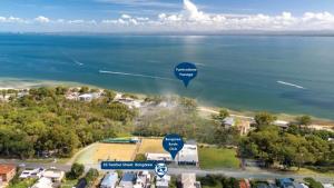 an overhead view of the ocean with two blue signs at Close to Water, Restaurants and Clubs, Toorbul St, Bongaree in Bongaree