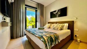 Un dormitorio con una cama y una ventana grande. en Luxury Beachfront Apt - Perfect for Beach Lovers, en Rivière Noire