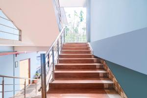 a staircase in a building with wooden floors and a window at FabHotel Roadside Inn in Naksalbāri