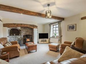 a living room with a couch and a fireplace at Cynynion Uchaf - Countryside Farmhouse with Views in Oswestry