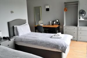 a bedroom with a bed and a desk with a chair at Bowood Park Hotel in Camelford
