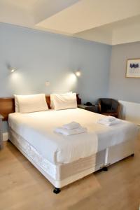 a bedroom with a white bed with two towels on it at Bowood Park Hotel in Camelford