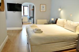 a bedroom with a large bed with towels on it at Bowood Park Hotel in Camelford +37 photos