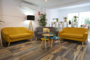 uma sala de estar com duas cadeiras amarelas e uma mesa em Hotel Teide em El Arenal
