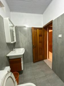 baño con aseo, lavabo y puerta en BIZI HOMES, en Kigali