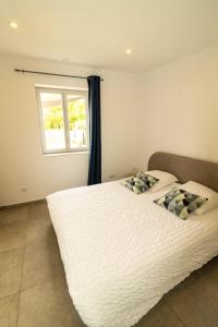 een slaapkamer met een groot wit bed en een raam bij Côté Verdon in Quinson
