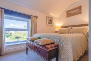 a bedroom with a large bed and a window at L'al Cottage, Sockbridge in Penrith