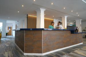 a man and woman standing at a counter in an office at Hotel Teide in El Arenal